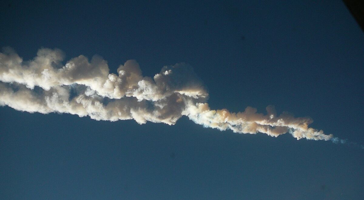 Извилистый белый дымный след челябинского метеора на синем утреннем небе