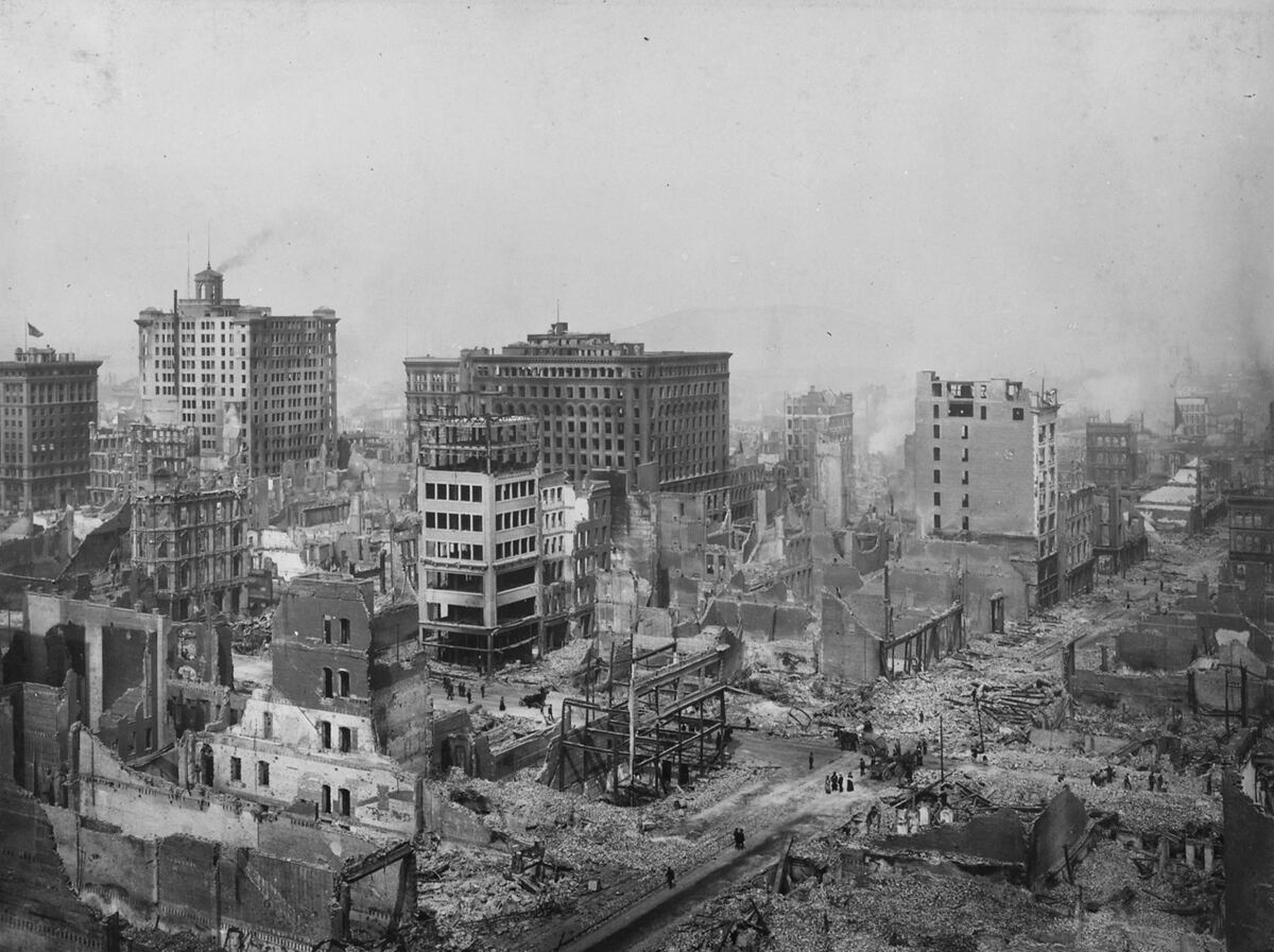1906'da San Francisco merkezinin Post Street ile Grant Avenue yakınından panoraması: içi yanmış tuğla binalar ve moloz, arada ayakta kalmış birkaç çelik karkaslı yüksek bina